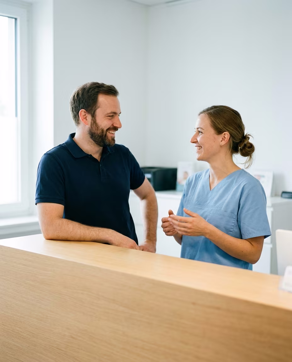 Laborinhaber im Gespräch mit einer Zahnärztin am Empfang der Praxis